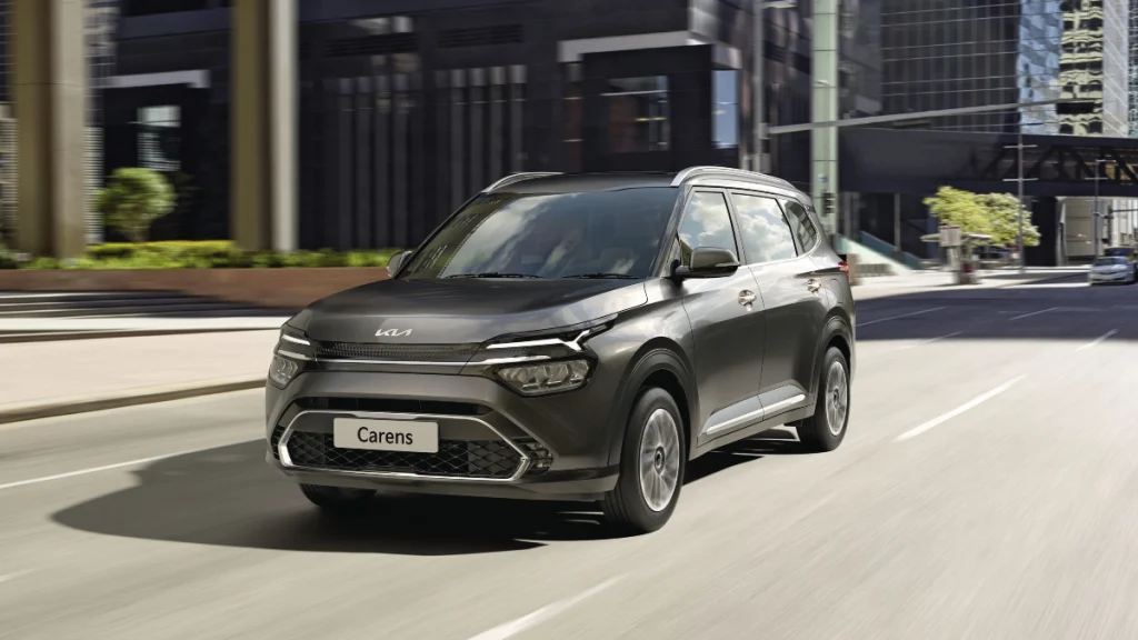 Kia Carens 2025 model driving on city road – stylish and spacious family SUV with modern design and advanced features